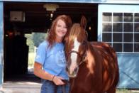 A smiling student with a horse